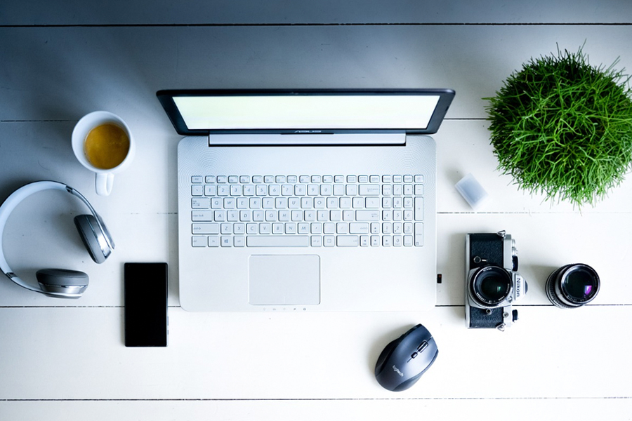 A phone, camera, headphones, and a laptop